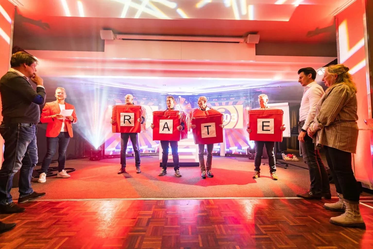 Teams spelen een letterspel tijdens De Bedrijfsborrel Show op locatie