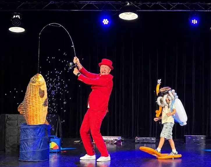 Pieter speelt met een reuzenvis van ballonnen en een kind in duikuitrusting
