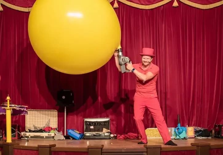 Pieter met een grote gele ballon op het podium tijdens zijn kindershow